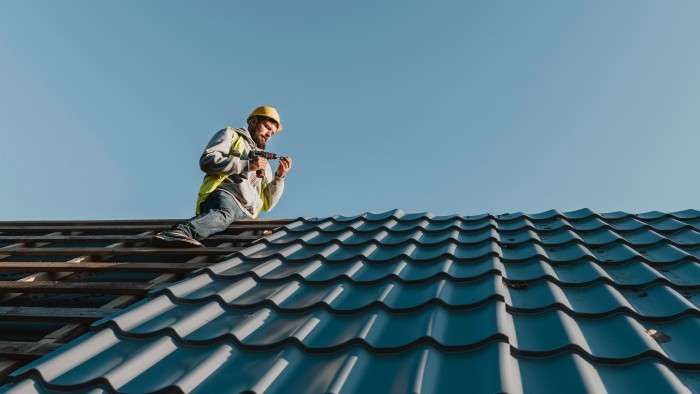 photo long shot man working on roof